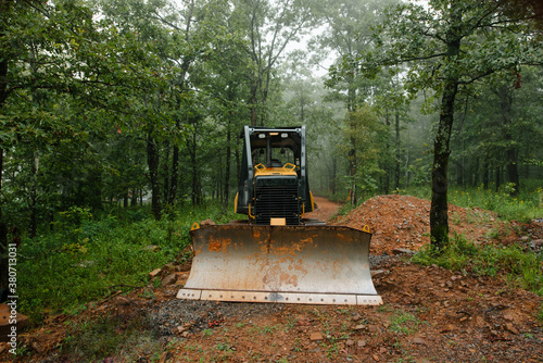 Bulldozer cutting a road in a forest