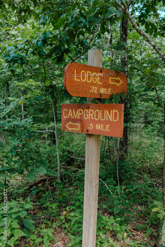 Lodge and campground sign on a forest trail Lodge and campground sign on a forest trail
