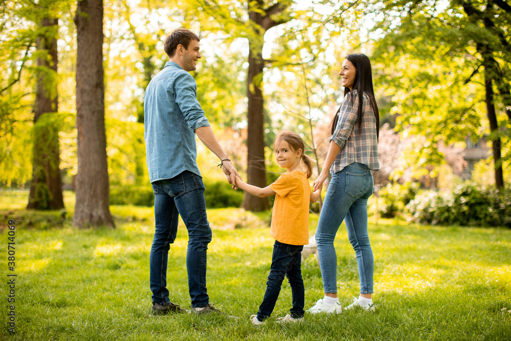 Obraz premium Happy family with cute bichon dog in the park
