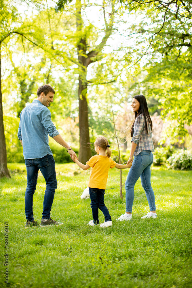 Happy family with cute bichon dog in the park Happy family with cute bichon dog in the park