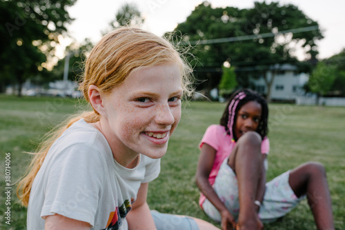 Smiling redhead girl and friend at sunset photo