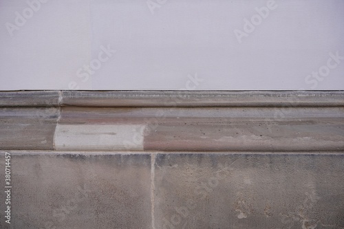 Ausschnitt einer alten Hausfassade mit rötlichem Sandstein und hellem Putz