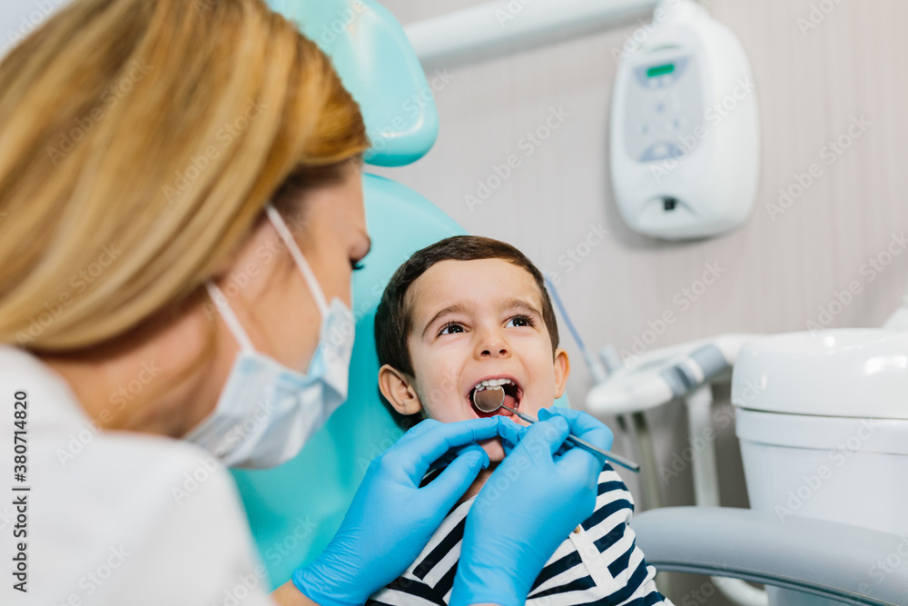 Dentist examining teeth of boy at workplace Dentist examining teeth of boy at workplace