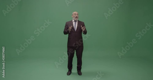 Studio, slow motion, green screen, mature man silences his audience, London, UK photo