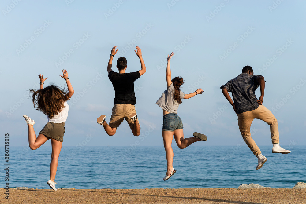 Happy friends jumping for joy by the sea Happy friends jumping for joy by the sea