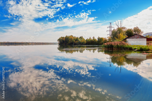 Reservoir on the Chepet River, Chepetskoe. It's a bright day, beautiful clouds and blue sky are reflected in the water mirror.