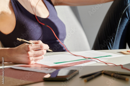 Woman filling reports while working at desk in sunlight