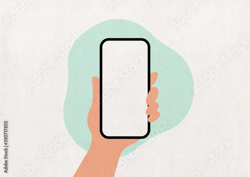 Hand holding a phone with blank screen on a mint paper background photo