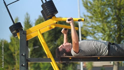 Man trining top part of pectoral muscules in park photo