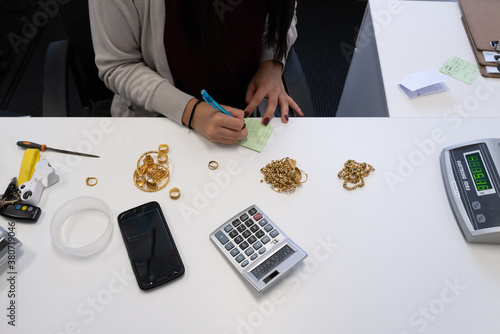 Gold dealer weighing and pricing value of gold jewellery