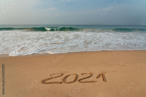 Sand beach with 2021 figures, New Year symbol and blue waves, Sri Lanka