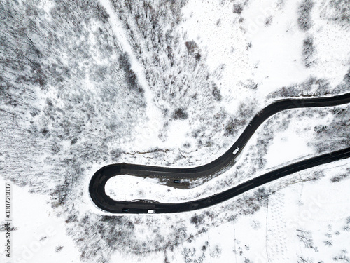 Beautiful aerial view of a curvy winding road with serpentine and white snow trees © Rafaila Gheorghita