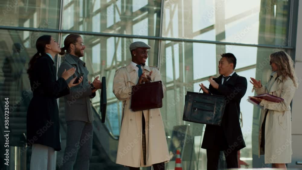 Inspired successful multi-ethnic business team with boss applauding celebrating corporate achievements teambuilding. Airport building. Business trip. Colleagues. Inspired successful multi-ethnic business team with boss applauding celebrating corporate achievements teambuilding. Airport building. Business trip. Colleagues.
