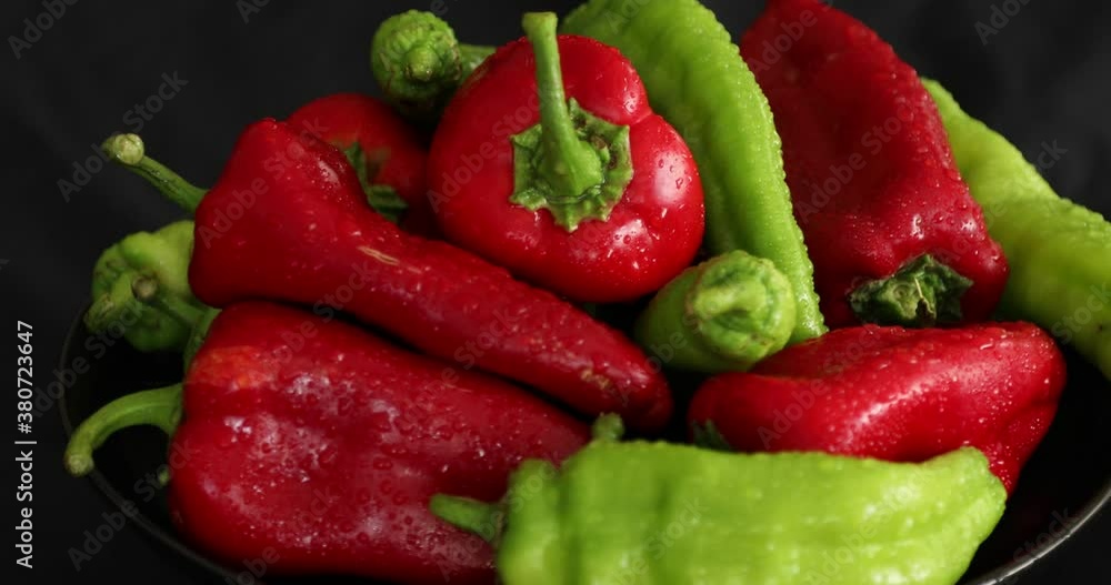 Red and green pepper rotating on black background Red and green pepper rotating on black background