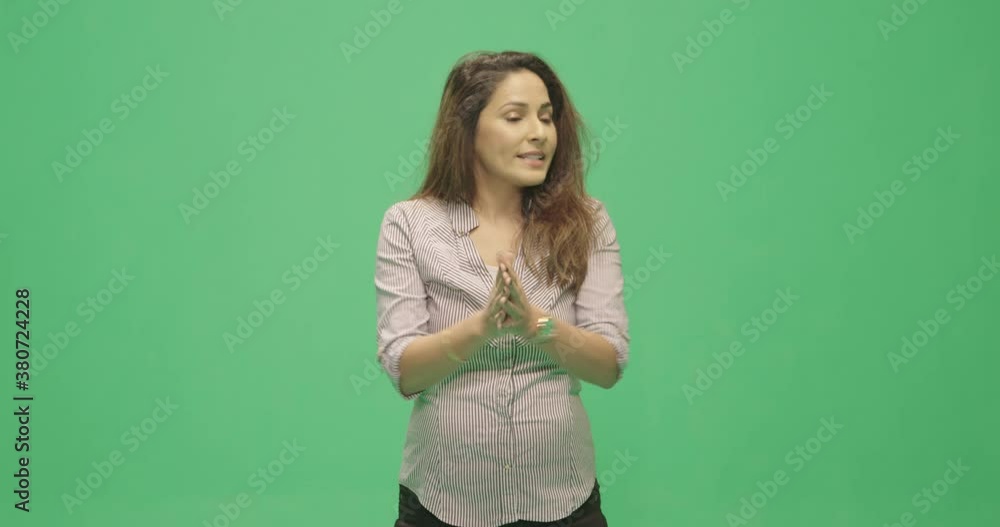 Studio, slow motion, green screen, young female lecturer silences her audience, London, UK Studio, slow motion, green screen, young female lecturer silences her audience, London, UK