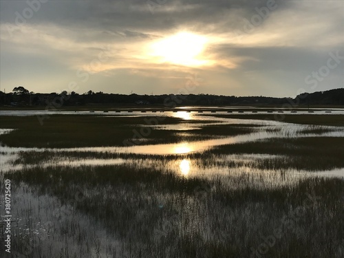 A sun shining on an expansive grassland. 