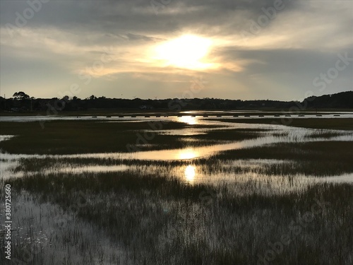 A sun shining on an expansive grassland. 