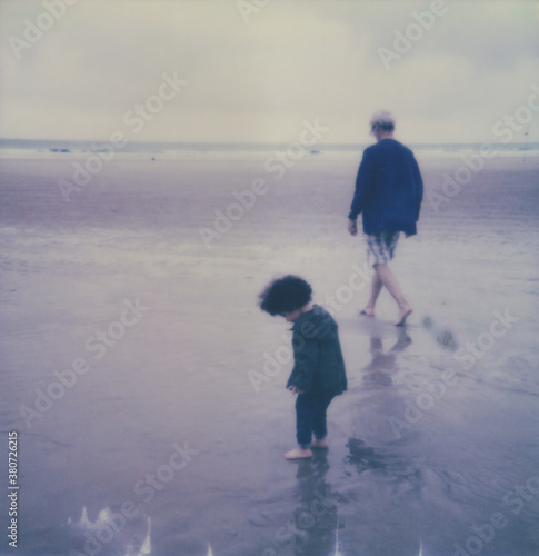 Polaroid photo of a toddler and grandfather at the beach