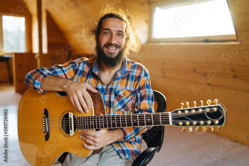 Portrait of a smiling bearded man with a guitar photo