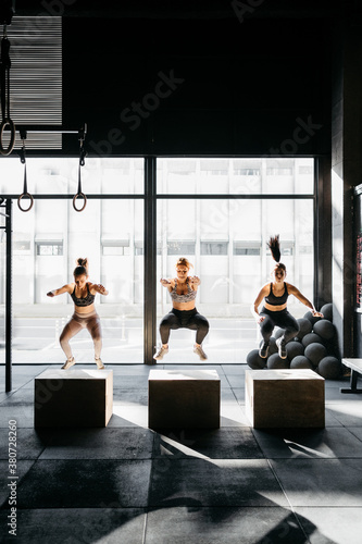 Group of women box jumping during a crossfit training photo