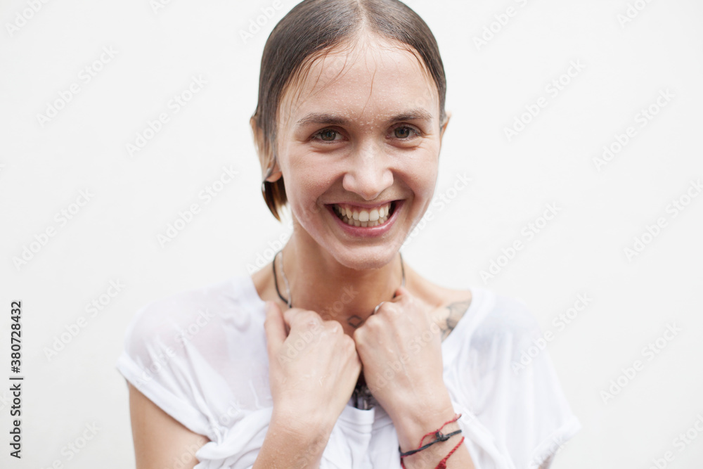 Smiling face of a young woman with flowing drops of water Smiling face of a young woman with flowing drops of water