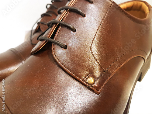 Classical male brown leather shoes in close-up on a white background