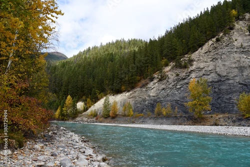 A blue river winds through the Canadian Rockies on a fall day