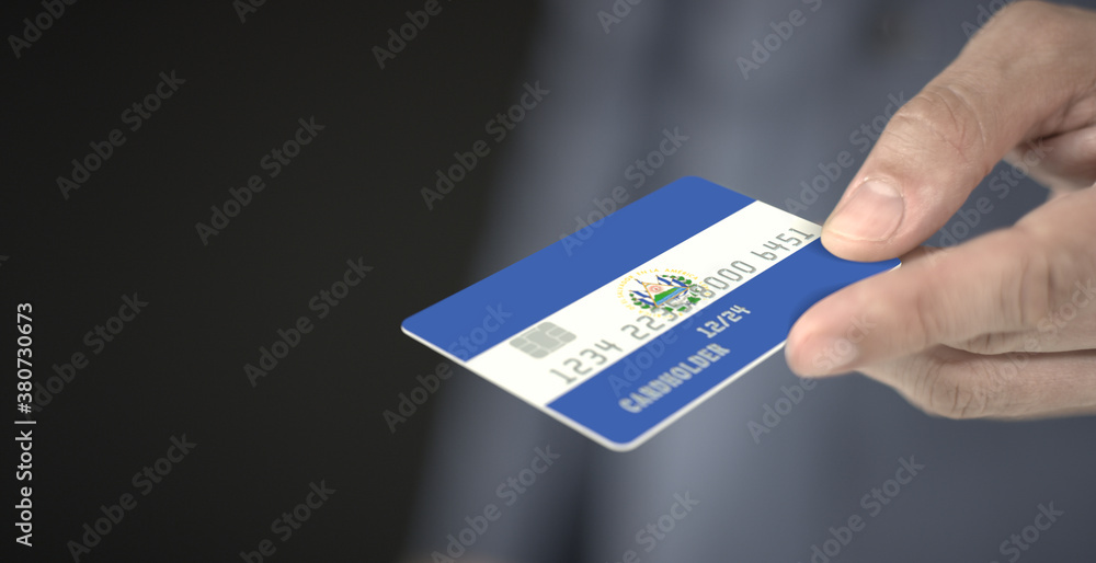 Man gives credit card with flag of El Salvador. Fictional numbers Man gives credit card with flag of El Salvador. Fictional numbers