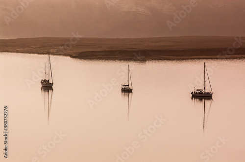 3 anchored boats in hazy light photo