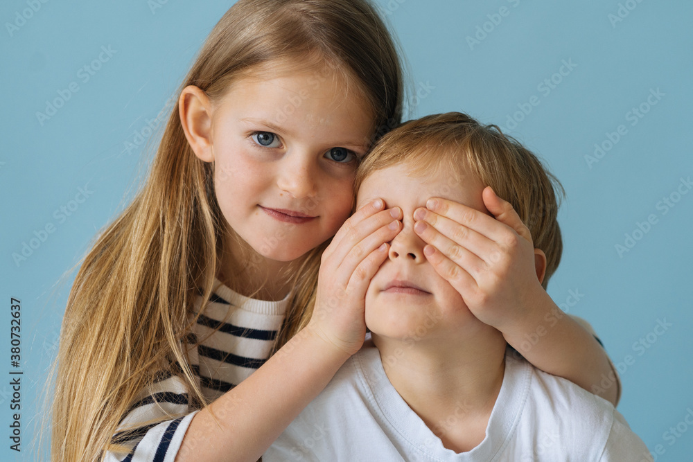 portrait of two beautiful children on a blue background portrait of two beautiful children on a blue background