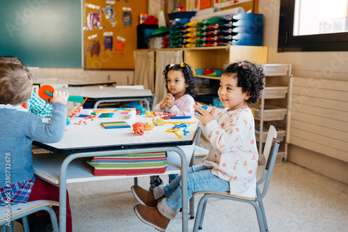 Diverse kids playing with modeling clay photo