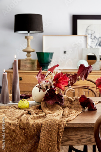 A still life of a dining table and a sideboard with art and marble and glass sculptures, photo