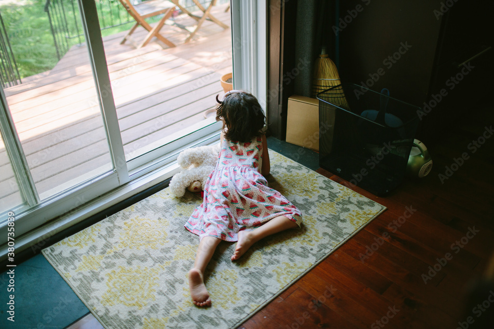 Kid laying on the floor looking outside Kid laying on the floor looking outside