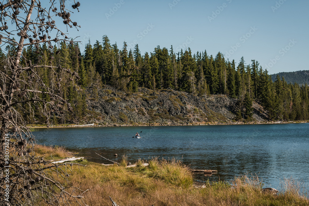 people kayaking on lake and near the mountains