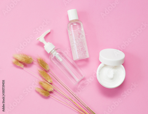 care  organic cosmetics for the face. Cream white and transparent bottles on a pink background