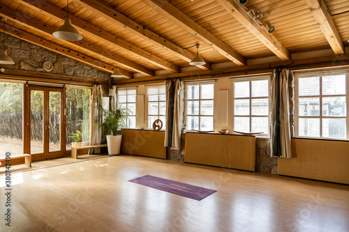 Yoga mat placed on wooden floor inside spacious pavilion decorated in oriental style located in tropical country photo