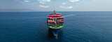 Aerial drone panoramic ultra wide photo of industrial container tanker ship loaded with colourful truck size containers cruising open ocean deep blue sea