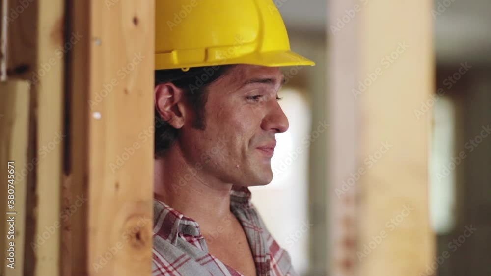 Construction worker wearing hard-hat on job site using mobile phone Construction worker wearing hard-hat on job site using mobile phone