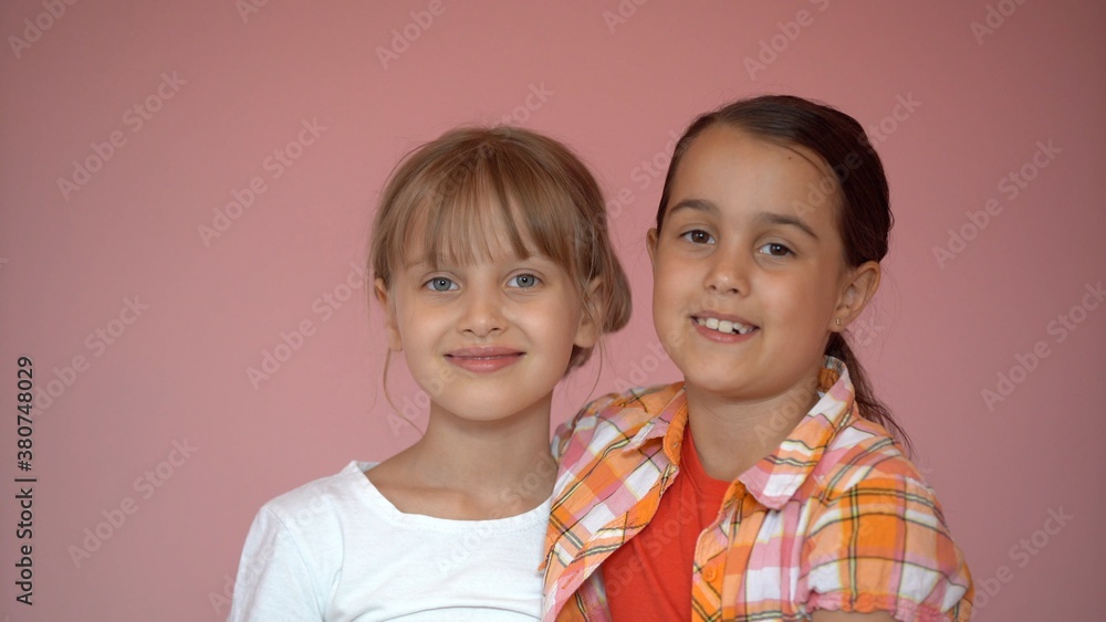 Portrait of two nice-looking attractive charming cute lovely friendly cheerful pre-teen girls isolated on pink pastel background Portrait of two nice-looking attractive charming cute lovely friendly cheerful pre-teen girls isolated on pink pastel background