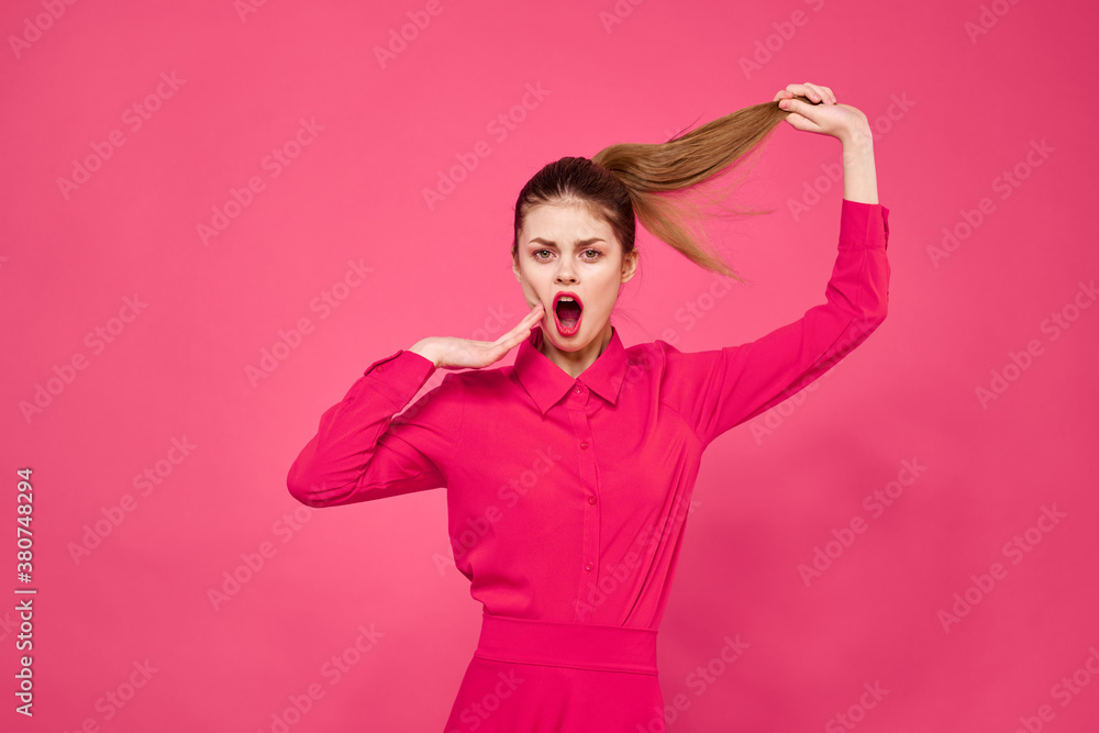 Portrait of a red-haired woman in bright clothes on a pink background cropped view of gesturing with her hands Portrait of a red-haired woman in bright clothes on a pink background cropped view of gesturing with her hands