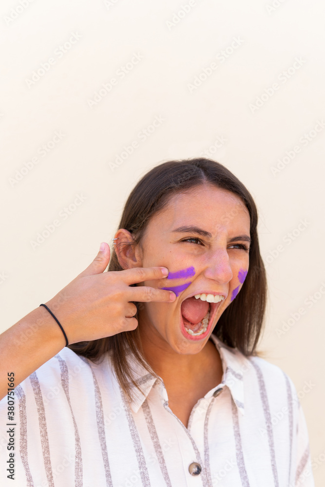 Expressive female with war paint on face screaming in city demonstrating concept of girl power Expressive female with war paint on face screaming in city demonstrating concept of girl power
