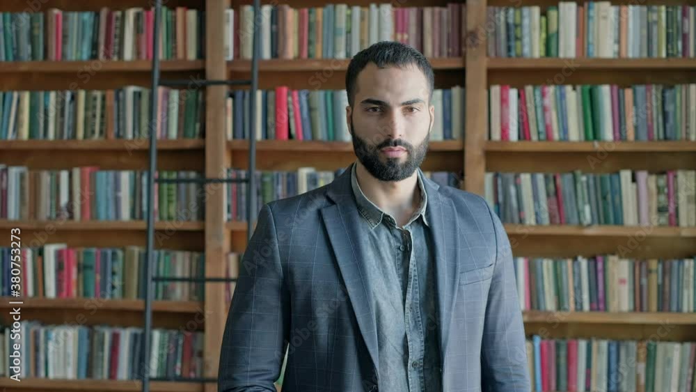 Serious Young Oriental Man Standing In The Library. Serious Young Oriental Man Standing In The Library.