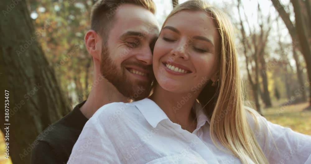 Portrait of lovely couple having relax in embraces and kisses on park bench Portrait of lovely couple having relax in embraces and kisses on park bench