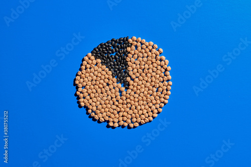 Top view of grain placed on blue table in shape of pie chart showing ratios in percentage
