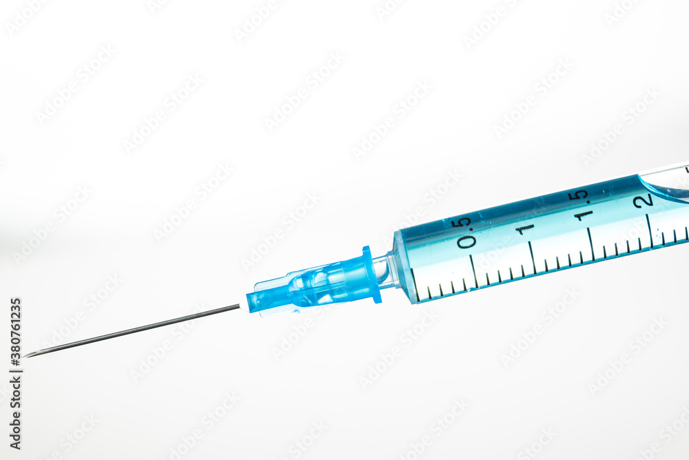 Syringe with a blue vaccine on a white background. Syringe with a blue vaccine on a white background.