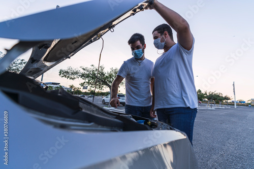 Wallpaper Mural Dos hombres con mascarilla revisando motor de un coche Torontodigital.ca