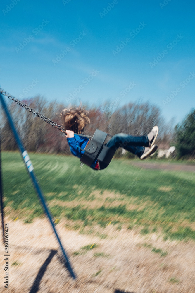 Child swinging in the spring with motion blur Child swinging in the spring with motion blur