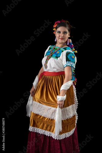 Mujer latina, bailarina con traje tradicional del estado de Michoacán, mexicana, con blusa bordada y grandes trezas de listones multicolores, aretes de liston y collares de cuentas, con rebozo blanco  photo