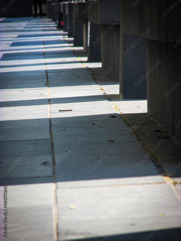 Shadows of concrete benches along the Southbank Promenade. This riverside location has a great atmosphere amidst street performers, cafes, restaurants, river cruises, shops, arts and markets. Shadows of concrete benches along the Southbank Promenade. This riverside location has a great atmosphere amidst street performers, cafes, restaurants, river cruises, shops, arts and markets.