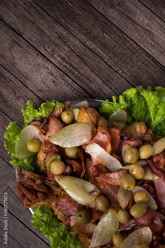 Portion of Fried Chicken made with rustic onions, bacon, olives and lettuce. Fried Chicken. Brazilian typical food. Vertical gourmet photography with top space for texts.